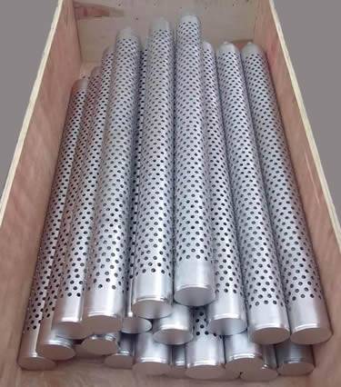 A lot of stainless steel perforated candle filters in a wooden box.